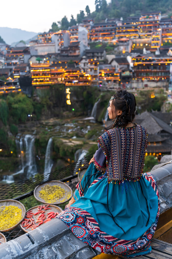 CHICA SENTADA OBSERVANDO LA CIUDAD LIJIANG
